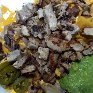 Carnitas nachos with sour cream , jalepenos, guac sauce, and nacho sauce