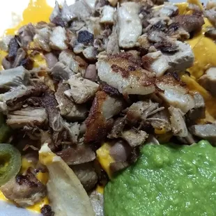 Carnitas nachos with sour cream , jalepenos, guac sauce, and nacho sauce