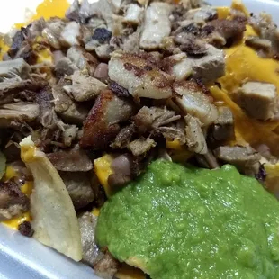 Carnitas nachos with sour cream , jalepenos, guac sauce, and nacho sauce