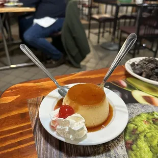 a plate of flan and whipped cream