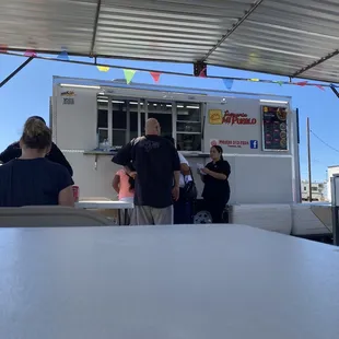 a group of people standing in front of a food truck