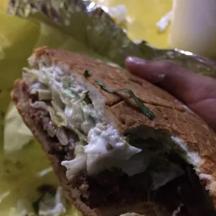 a hand holding a sandwich