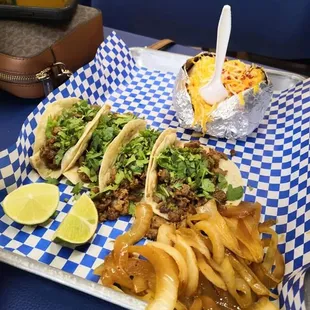 a tray of tacos and fries