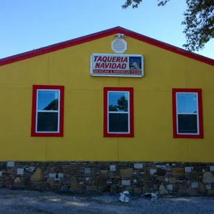 a yellow building with red trim