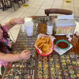 a little girl sitting at a table