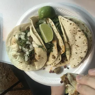 a plate of tacos with lime wedges