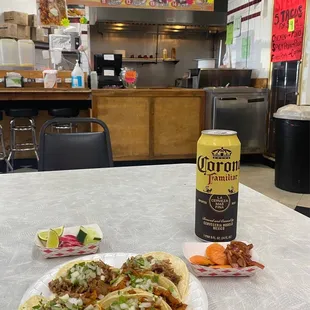 a plate of tacos and a can of corona