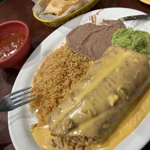 Chimichanga with fajita chicken, queso, rice , beans , guacamole