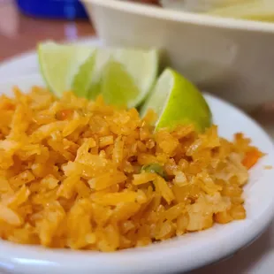 a plate of rice with lime wedges