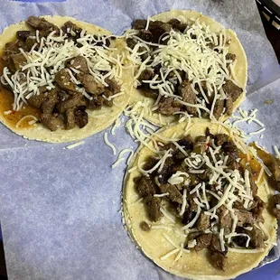 three tacos with meat and cheese