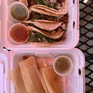 a couple of tacos in a styrofoam container