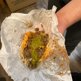 a person holding a burrito