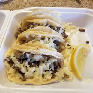 three tacos in a styrofoam container