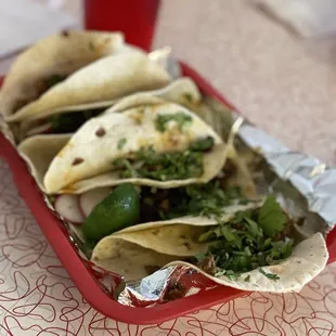 a tray of tacos and a drink