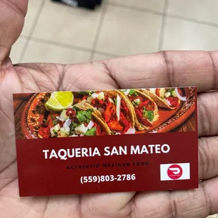 a hand holding a business card