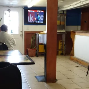 View of the front half of the seating area. The bathroom is the door just to the left of the front counter