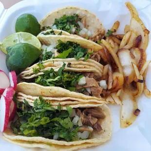 Street tacos. 2 lengua and 2 carnitas, all with cilantro and diced onion. Accompanied with lime, radish and grilled onion.