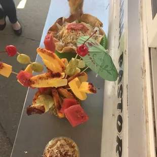 In this picture you can see Fruit, elote(corn in a cup), and Super Tostada.