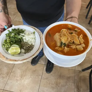 a man holding two plates of food