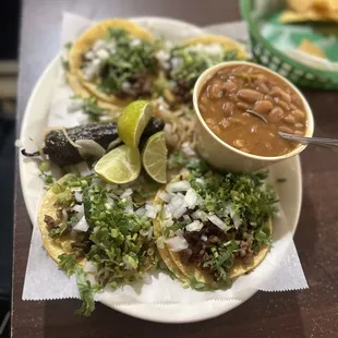 a plate of tacos with beans and salsa