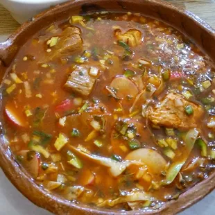 Pozole rojo with cabbage, radishes, onions, chopped jalapeno, and fresh squeezed lime.  Soooo good