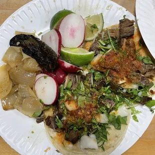 a plate of tacos with meat and vegetables