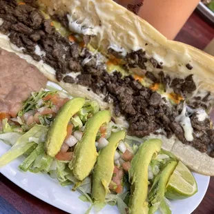 a plate of tacos with meat and avocado