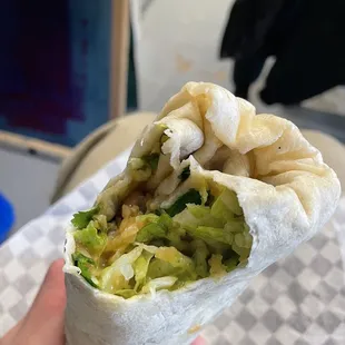 a hand holding a burrito