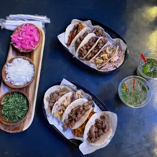 a table with tacos, salsa, and a drink