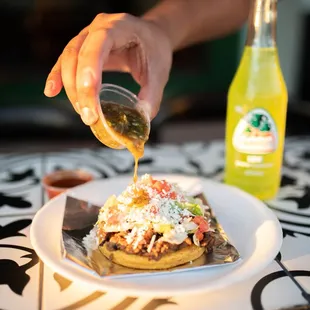 a plate of food being drizzled with sauce