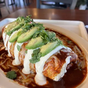 A wet chicken burrito with a healthy topping that was placed so decadently.  The chicken red sauce was the right temperature and texture.