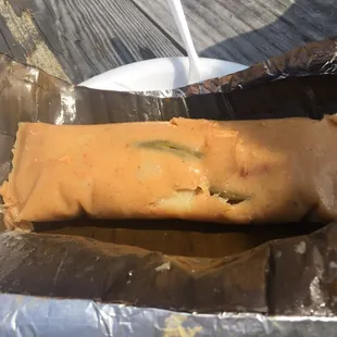 Delicious huge chicken tamale unwrapped from aluminum foil