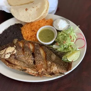 whole tilapia fried with rice, bean,salad and hand make tortillas