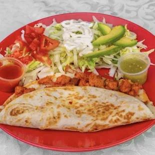 Taqueria Yolandita&apos;s Quesadilla includes: lettuce, tomatoes, sour cream, cheese, onions &amp; sauce on the side.