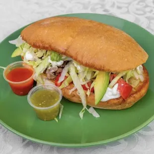 Taqueria Yolandita&apos;s Torta Sandwich includes: lettuce, tomatoes, onions, sour cream, Mayo, cheese, avocado, and meat of choice.