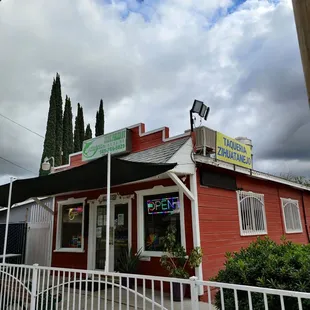 a red building with a white fence