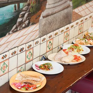 a row of plates of food on a table
