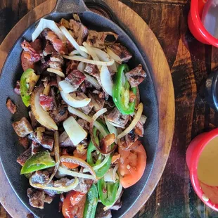 Special beef fajitas with bacon, onion, tomatoes, and jalapenos.