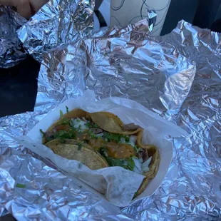 a taco wrapped in aluminum foil