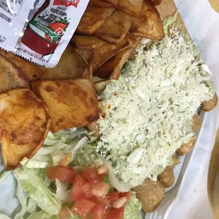 a taqueria sandwich with lettuce, tomato, onion,