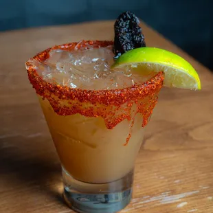 a close up of a margarita with a lime slice