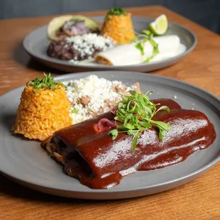 two plates of mexican food on a wooden table