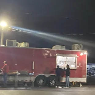 a group of people standing in front of a food truck
