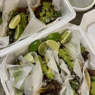 a variety of tacos in a styrofoam container