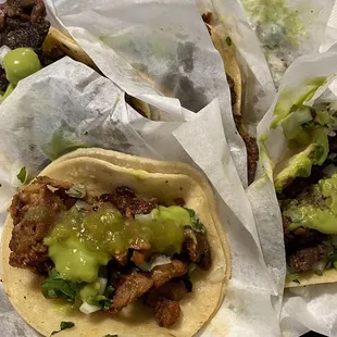 three tacos on a checkered table cloth