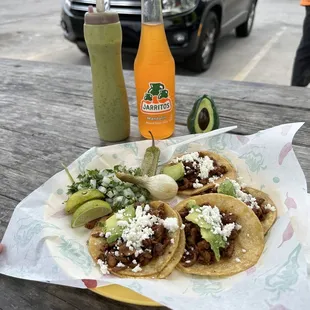 Mini plate of tacos al pastor and a Jarritos soda.