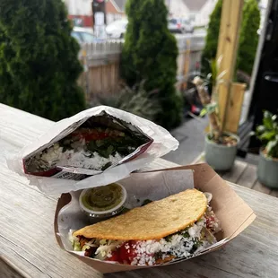 a sandwich and a side dish on a table