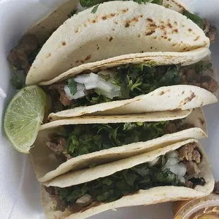 three tacos in a styrofoam container