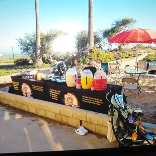 Rice, beans, condiments, garnishes, sauces bar, and agua frescas setup