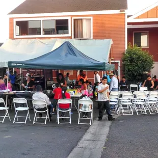 a group of people sitting under a tent